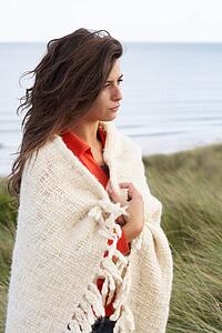 Young Woman Standing In Sand Dunes Wrapped In Blanket