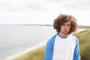 Young Man Standing In Sand Dunes