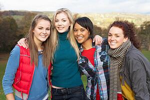 Group Of Four Teenage Female Friends In Autumn Landscape