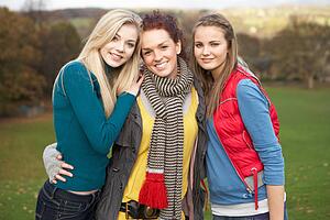 Group Of Three Teenage Female Friends In Autumn Landscape