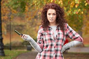 Frustrated Teenage Girl Making Mobile Phone Call In Autumn Landscape