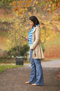 Teenage Girl Making Mobile Phone Call In Autumn Landscape