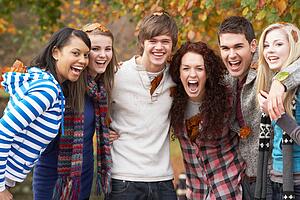 Group Of Six Teenage Friends Having Fun In Autumn Park