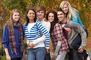 Group Of Six Teenage Friends Having Fun In Autumn Park