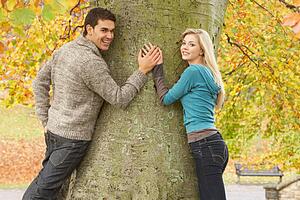 Romantic Teenage Couple By Tree In Autumn Park