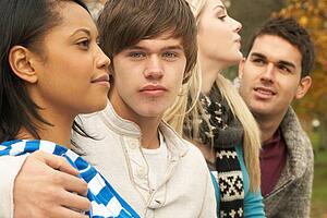 Close Up Of Group Of Four Teenage Friends In Autumn Woodland