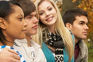 Close Up Of Group Of Four Teenage Friends In Autumn Woodland