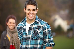 Teenage Boy Outside With Girlfriend In Background