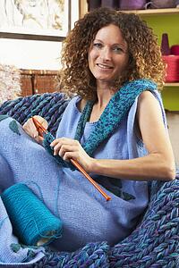 Close Up Of Woman Sitting In Chair Knitting