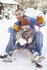 Father And Son Sitting On Sledge
