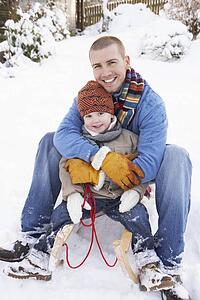 Father And Son Sitting On Sledge