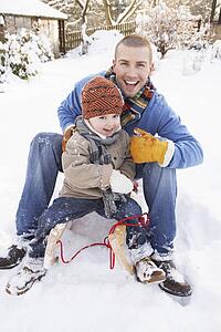 Father And Son Sitting On Sledge