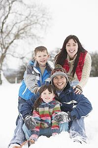 Family Having Fun In Snowy Countryside