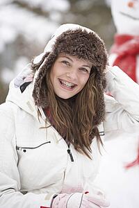 Teenage Girl Wearing Winter Clothes In Snowy Landscape