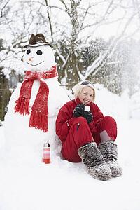 Teenage Girl Next To Snowman With Flask And Hot Drink