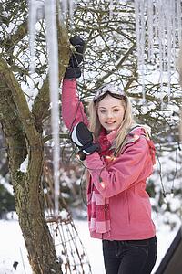 Teenage Girl Hanging Fairy Lights In Tree With Icicles In Foreground