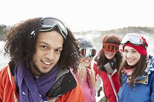 Group Of Teenage Friends Having Fun In Snowy Landscape Wearing Ski Clothing