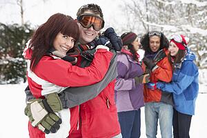 Group Of Teenage Friends Having Fun In Snowy Landscape Wearing Ski Clothing