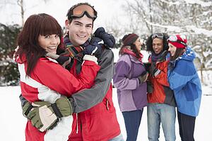 Group Of Teenage Friends Having Fun In Snowy Landscape Wearing Ski Clothing