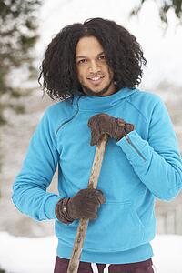 Young Man Clearing Snow From Drive