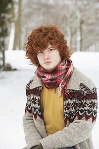 Teenage Boy Wearing Winter Clothes In Snowy Landscape