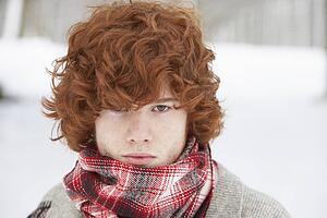 Teenage Boy Wearing Winter Clothes In Snowy Landscape