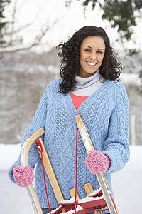 Woman Holding Sledge In Snowy Landscape