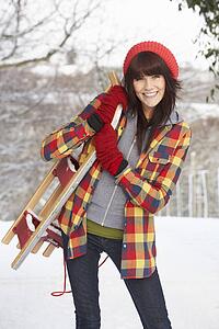 Woman Holding Sledge In Snowy Landscape