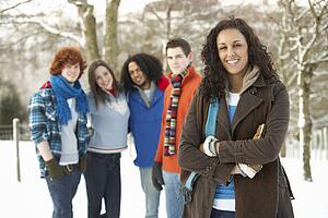 Group Of Teenage Friends Having Fun In Snowy Landscape Wearing Ski Clothing
