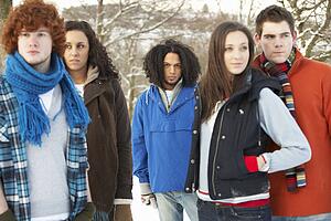 Group Of Teenage Friends Having Fun In Snowy Landscape Wearing Ski Clothing