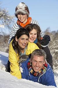 Young Family Having Fun In Snowy Landscape