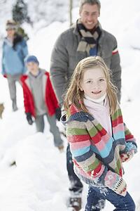 Family Enjoying Walk Through Snowy Landscape