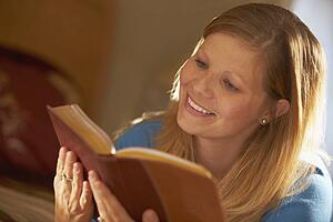 a young woman enjoys reading a book