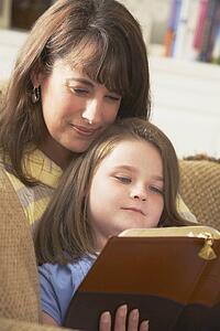 a mother and daughter read the bible together