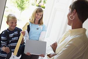 mother greeting children at the door as they're coming home from school