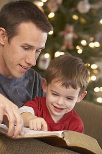 a father reading the bible to his young son