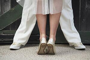 a bride standing on her tip toes in front of a groom