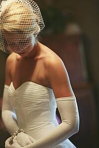 a bride wearing a strapless dress, long white gloves and a veil