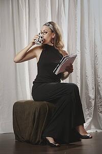 a woman drinking from her mug and holding a document