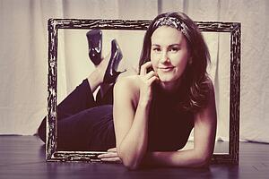 a woman with her upper body laying through a picture frame