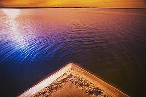 alberta, canada; a pier on the lake at sunset