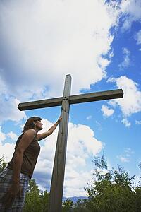 a woman touches the cross