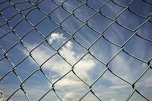 alberta, canada; the sky through a chain link fence
