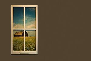 alberta, canada; view of a barn in a field through a window