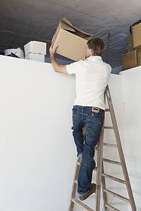 tarifa, cadiz, andalusia, spain; a man on a step ladder tidying up the attic