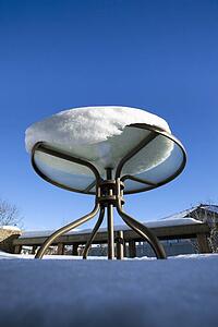 snow melting on a patio table; edmonton, alberta, canada