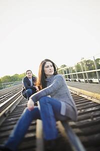 Hamilton, Ontario, Canada; A Couple Sitting On The Railroad Tracks