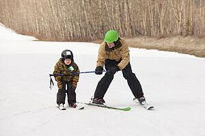 red deer, alberta, canada; a father teaching his young son how to ski
