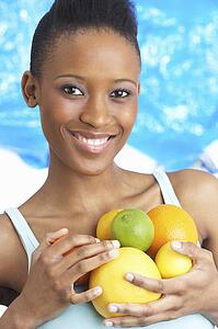 Young Woman Holding Citrus Fruit In Studio