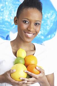 Young Woman Holding Citrus Fruit In Studio